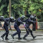Kratom Raid Sparks Ole Miss Mystery Police tactical team advancing in rain