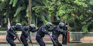 Kratom Raid Sparks Ole Miss Mystery Police tactical team advancing in rain