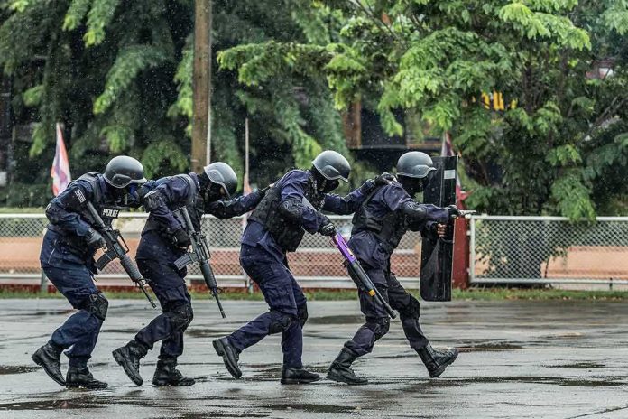 shutterstock_1115325713-1 Police tactical team advancing in rain