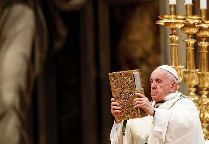 shutterstock_1376940776 Catholic priest holds ornate book during ceremony