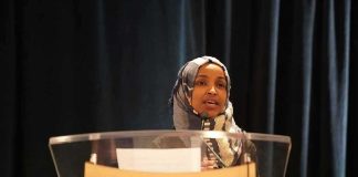 ICE Probe Targets Rep. Ilhan Omar – Warrant Mystery Deepens Woman in hijab speaking at a podium