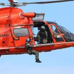 Coast Guard Scramble After Jet Disappears Rescue helicopter with crew performing hoist operation