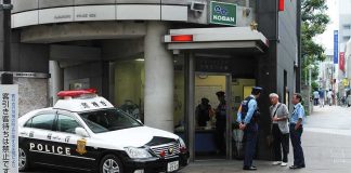 Japanese police box with patrol car and officers speaking to two men