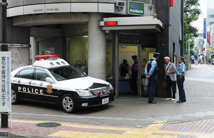 shutterstock_1499159699 Japanese police box with patrol car and officers speaking to two men