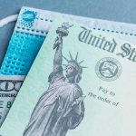 Obamacare Overcharge? $500 Checks Arrive U.S. Treasury check with face mask and hundred-dollar bill