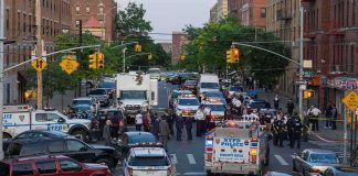 ICE Arrest Explodes Into Gunfire Police vehicles and officers block a city street during an active scene