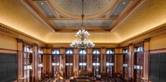 Ornate legislative chamber with curved rows of desks and grand chandelier