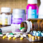 Magic Mushroom Jolt Stuns Doctors Medicine pills and syringe on table with brown bottle