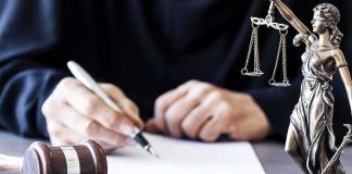 NFL Shock: Tyreek Hill Trial Explodes Judge writing at desk with gavel and Lady Justice statue
